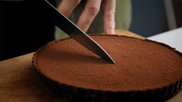 Dark chocolate tart being cut