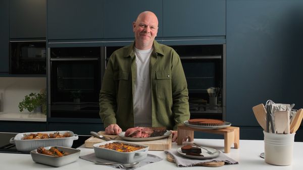 Tom Kerridge standing in NEFF kitchen with all created dishes