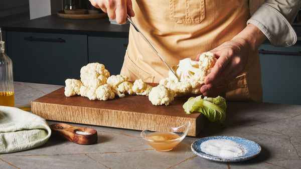 Cutting cauliflower on a wooden board