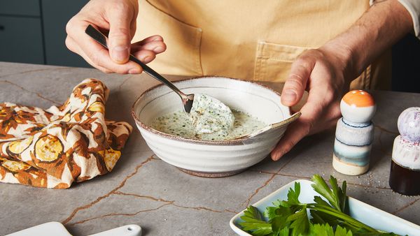 Mixing herbs into yogurt dip with a spoon