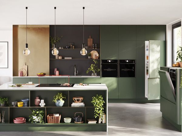 A contemporary kitchen featuring green cabinets and matching green appliances, creating a cohesive and stylish look.