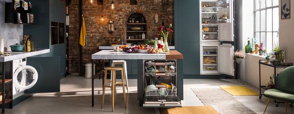 A modern kitchen featuring a sink, refrigerator, and washer, showcasing a functional and organized space for daily tasks.