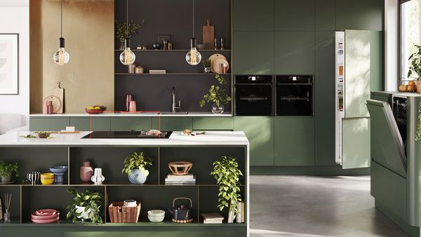 A stylish kitchen with green cabinetry and appliances, exemplifying modern design and a harmonious color scheme.