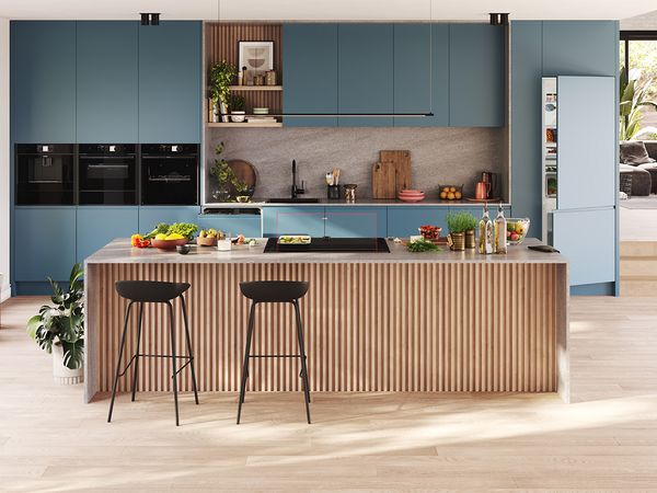 A contemporary kitchen featuring blue cabinets and elegant wooden flooring, showcasing a stylish and inviting atmosphere.