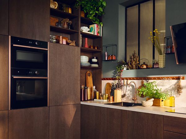 A cozy kitchen featuring wooden cabinets and a bright window, allowing natural light to illuminate the space. 