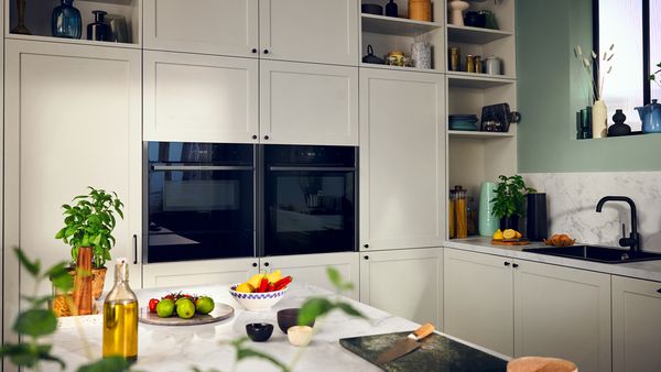 A modern kitchen featuring sleek white cabinets paired with stylish black appliances, creating a contemporary aesthetic.