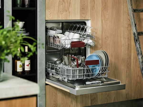 A modern dishwasher integrated into a wooden cabinet, accompanied by a sleek sink in a contemporary kitchen setting.