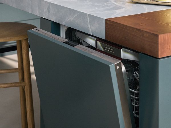 A modern kitchen featuring a sleek marble countertop and a stylish wooden stool for seating. 