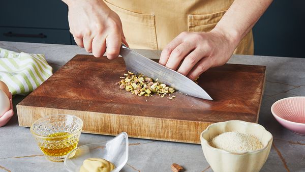 Taglio dei pistacchi su un tagliere in legno.
