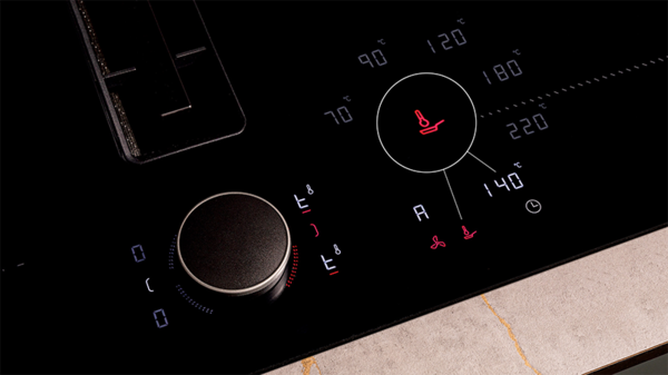 A close-up view of a stove top control panel featuring knobs and buttons for temperature and cooking settings.