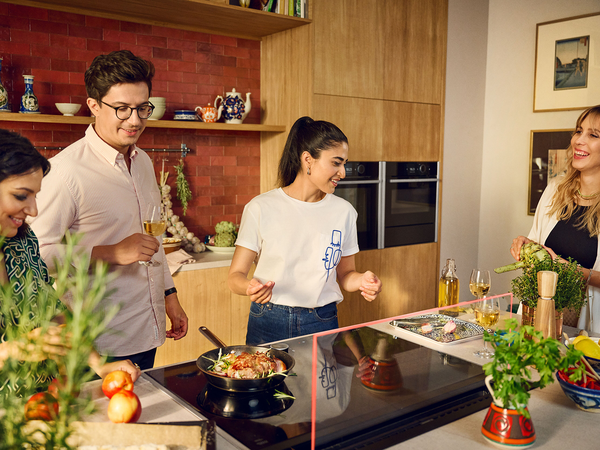 Group of people cooking in colourful kitchen area