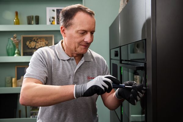 Close-up of a technician operating an oven.