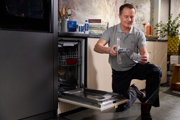 Engineer repairing a dishwasher.