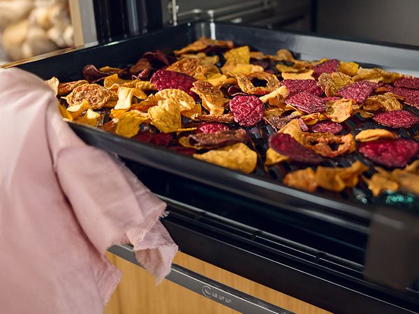 Open oven with tray of colourful airfried vegetables 