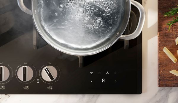 Vista dall’alto di un piano cottura a induzione Neff con una pentola d’acqua in ebollizione