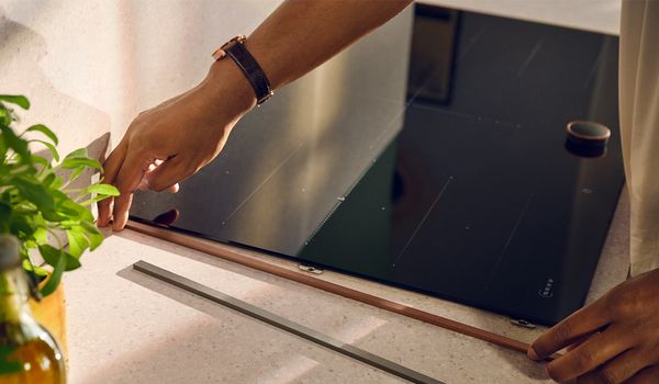 Κοντινή φωτογραφία με αντρικό χέρι που τοποθετεί το πλαϊνό αξεσουάρ της εστίας.