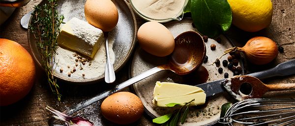 Chocolate dessert slices with pistachios, powdered sugar, rosemary, and cinnamon on a marble platter.