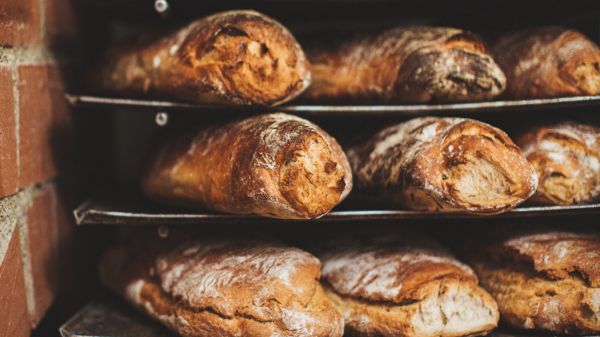 Handgemachte Brotlaibe auf Metallgestellen.