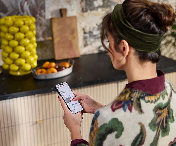 Woman using tablet in the kitchen to register appliances