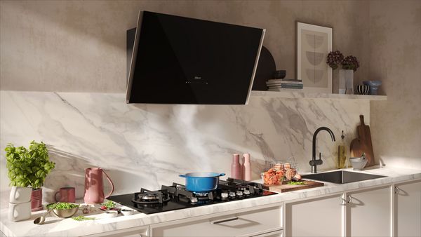 Cucina moderna con un piano cottura a gas e un'elegante cappa nera.