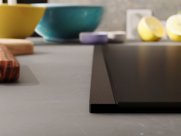 Matzwarte kookplaat met Deep Black Flex Design-zijlijst en donker marmeren werkblad