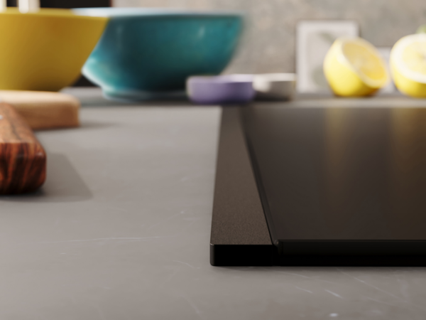 Detailansicht eines NEFF Induktionskochfelds mit Flex Design Seitenleiste in Deep Black, eingebaut in eine dunkle Küchenarbeitsplatte.
