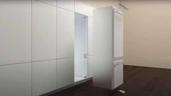 Einbaukühlschrank wird aus einer Küchennische herausgezogen.