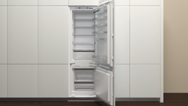 Geöffneter NEFF Einbaukühlschrank in moderner Küche mit leerem Innenraum; Tür ist weit geöffnet, Einbausituation und Innenstruktur gut erkennbar.