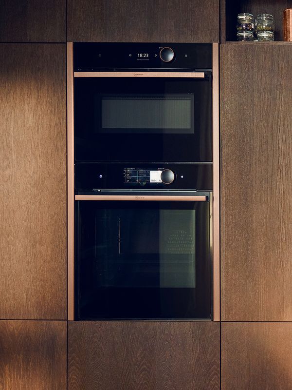 Топла, приветлива кухня с фурна NEFF, вградена в дървени шкафове