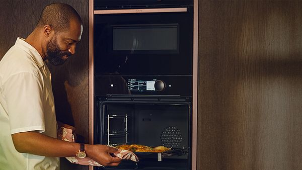 Person checking on food cooking in oven