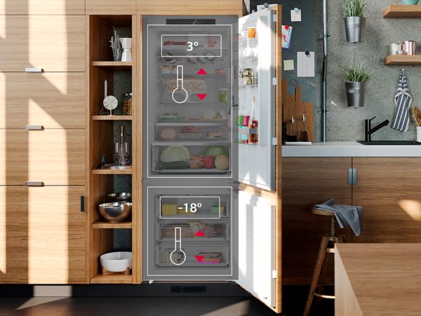 Una cucina dotata di pensili in legno con un frigo, immersa in un'atmosfera calda e accogliente.
