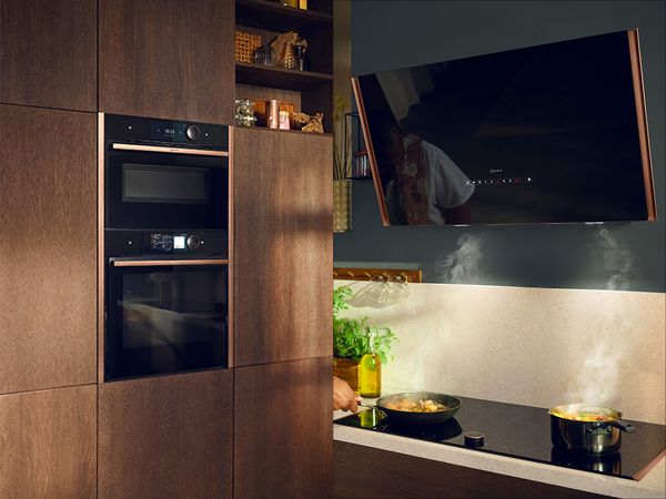 Decorated kitchen with multiple NEFF appliances and brushed bronze flex design