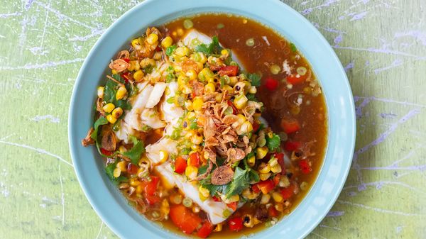 A blue plate with cod and colorful spiced beans.