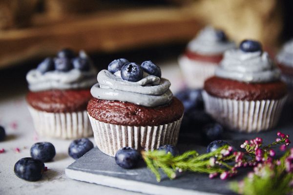 Muffin al cioccolato decorati con crema e mirtilli freschi