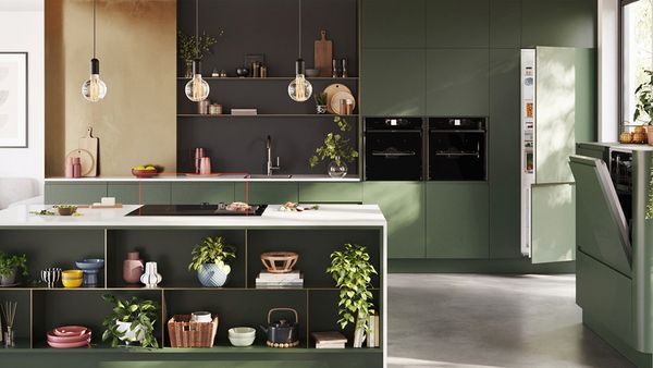 A modern kitchen featuring green walls and cabinets, showcasing a stylish and contemporary design.  