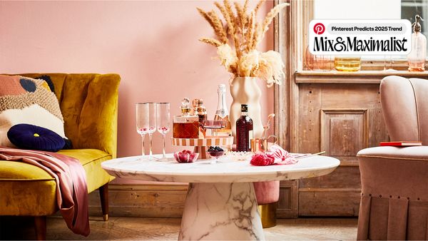 A pink living room featuring a table adorned with several wine bottles, creating an inviting atmosphere.  