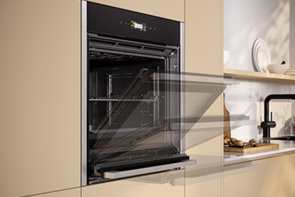Black NEFF oven with open door, installed in a modern kitchen.