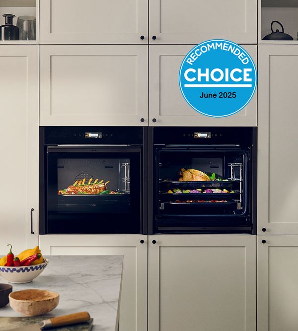 Two NEFF ovens in a kitchen with food cooking 
