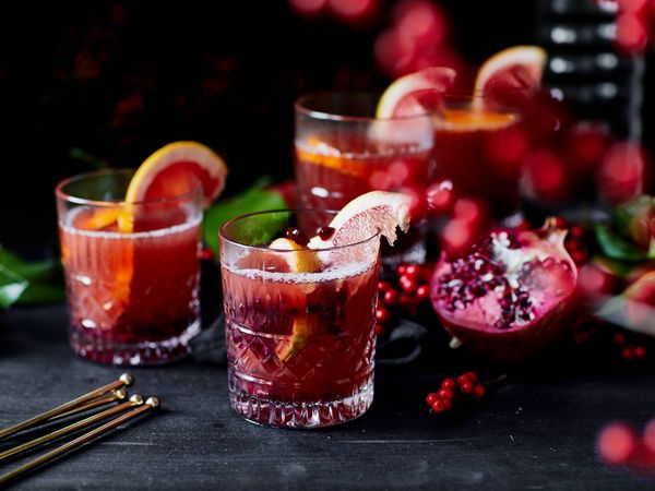 A flat lay of pears, cinnamon sticks, apples, spices, and herbs on a gray surface, creating a cozy autumn vibe.
