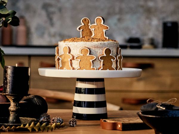 Chocolate dessert slices with pistachios, powdered sugar, rosemary, and cinnamon on a marble platter.