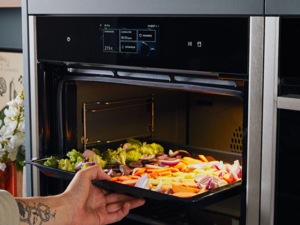 Airfry Backblech mit Gem&uuml;se wird in den NEFF Backofen geschoben.