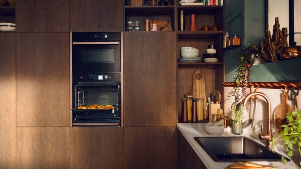 Man taking tray out of oven