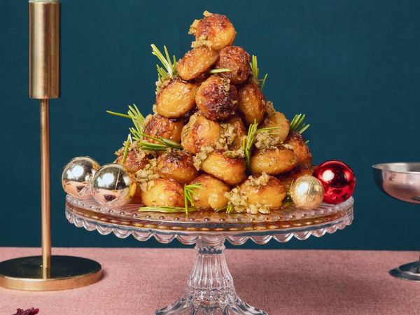 Tower of roast potatoes on a plate on top of table
