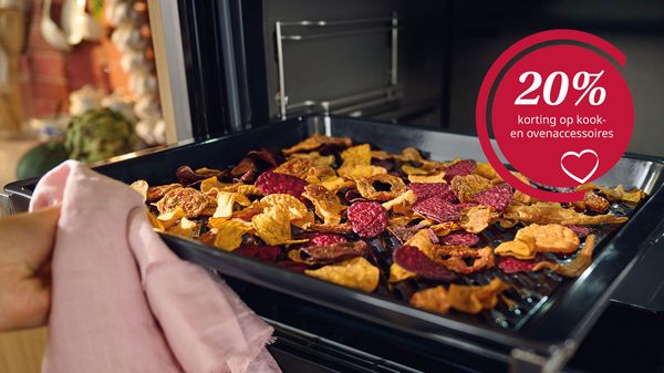 Bakplaat met groentechips in oven met daarnaast een button met 20% korting