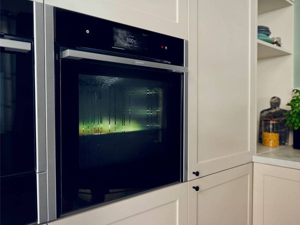 An open oven filled with various dishes cooking on multiple racks, including stuffed vegetables and bread, in a rustic kitchen.
