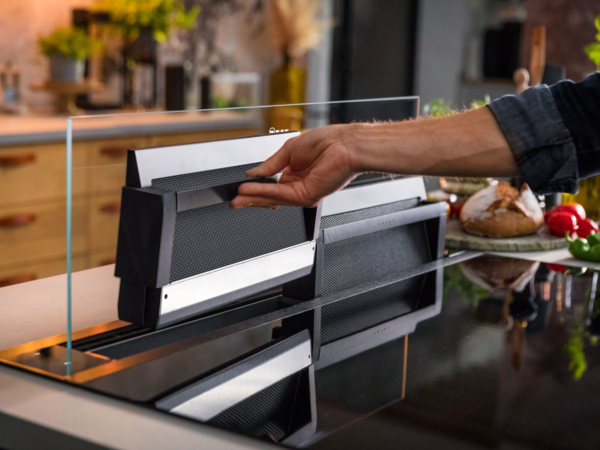 Ausfahrbarer Dunstabzug aus Glas mit entnehmbaren Metallfettfiltern im ge&ouml;ffneten Zustand.