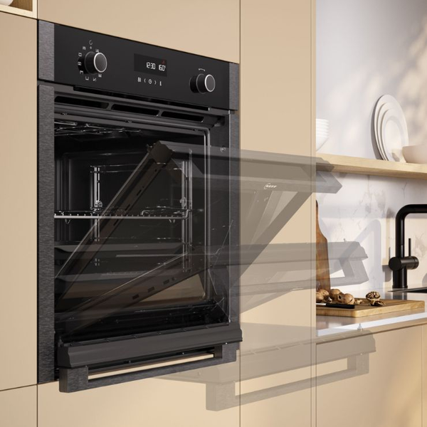 Einbau-Backofen von NEFF mit ge&ouml;ffneter Slide & Hide Backofent&uuml;r in moderner K&uuml;che.