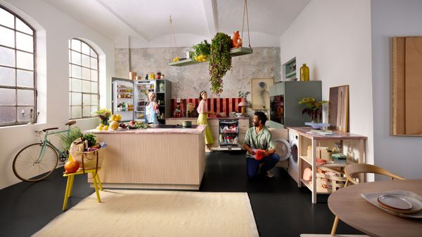 A man standing in front of an open refrigerator, inspecting food options.