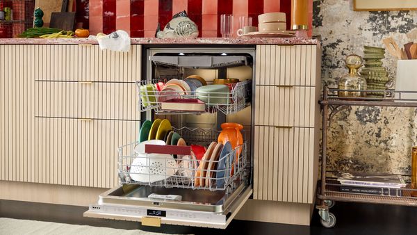A woman loading dishes into a dishwasher.