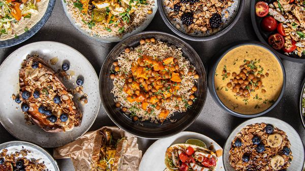Vista dall&rsquo;alto di piatti con preparazioni dolci e salate disposti su un tavolo grigio
